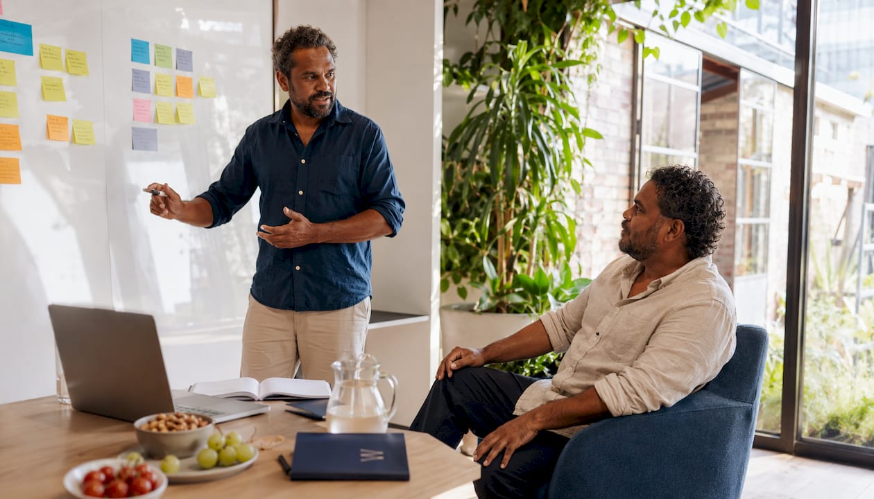 Two men discussing compliance in meeting