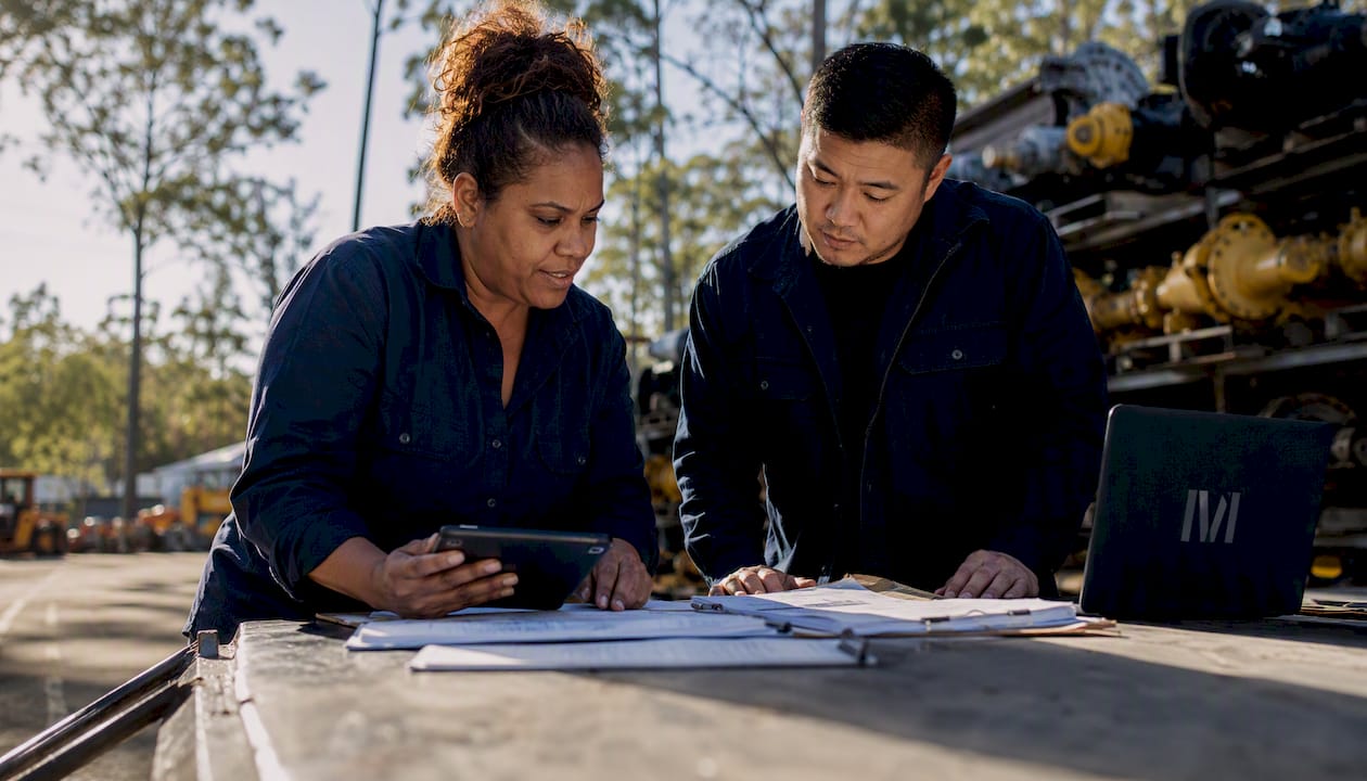 Two dealership staff collaborating in workshop area