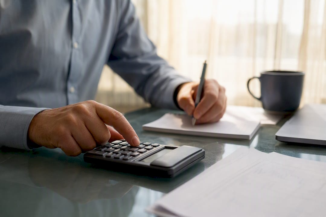 Hands calculating financial data at desk