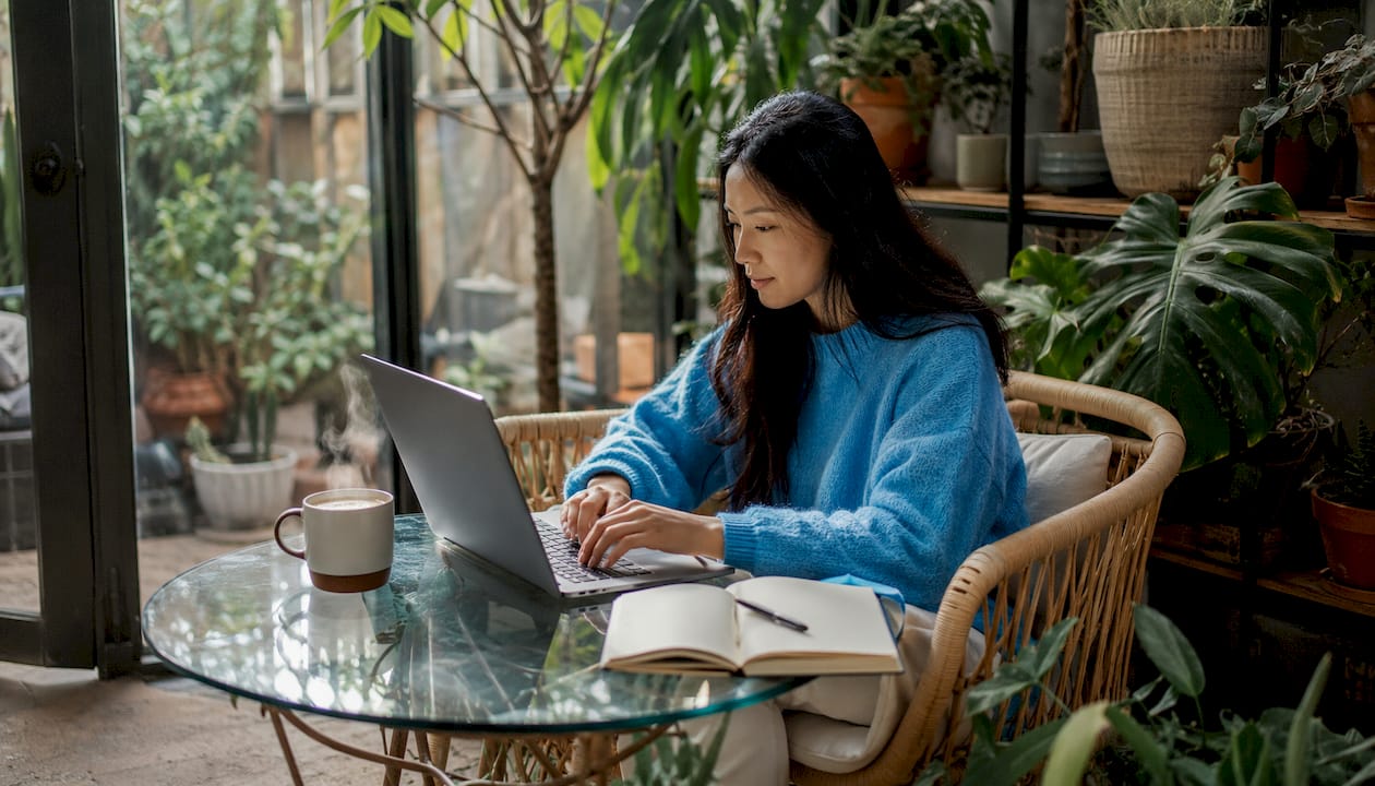Des mains tapent sur un clavier d’ordinateur dans un espace de coworking.
