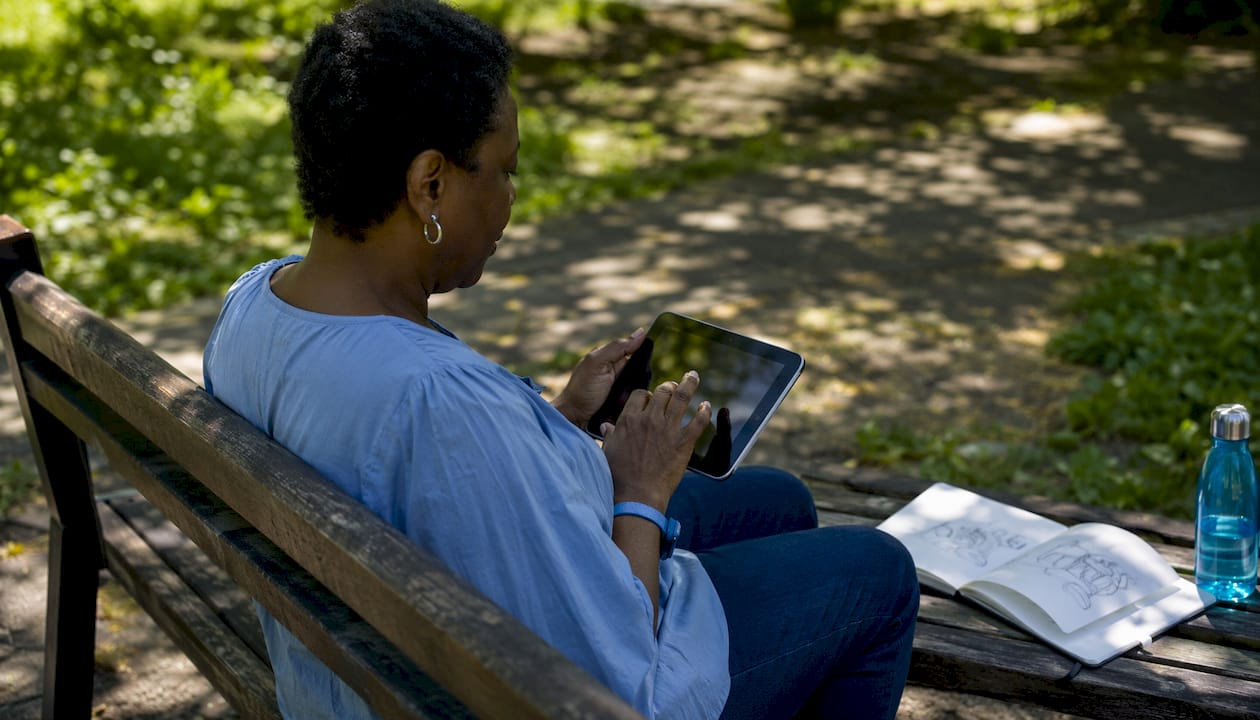 Une femme consulte des plans techniques d’architecture sur sa tablette.