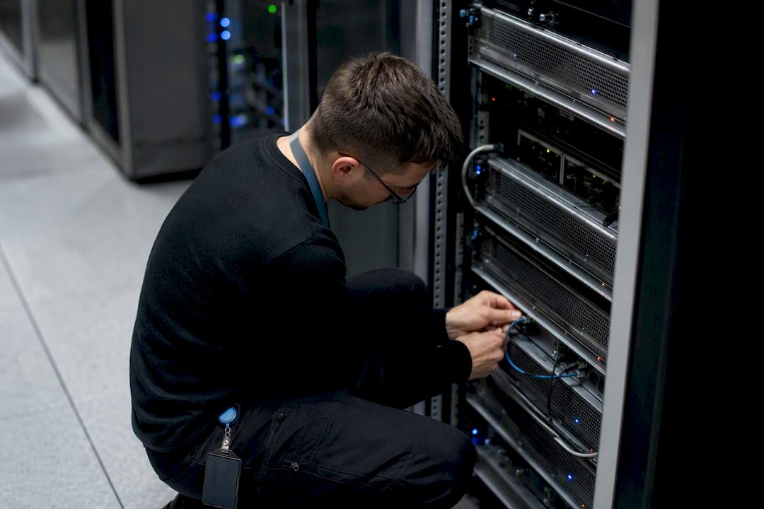 Hand connecting a network cable to a server