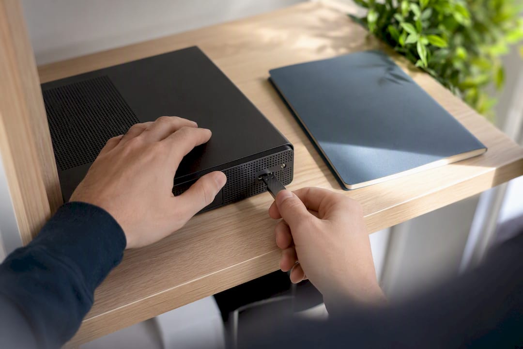 Hands attaching a security key to a laptop