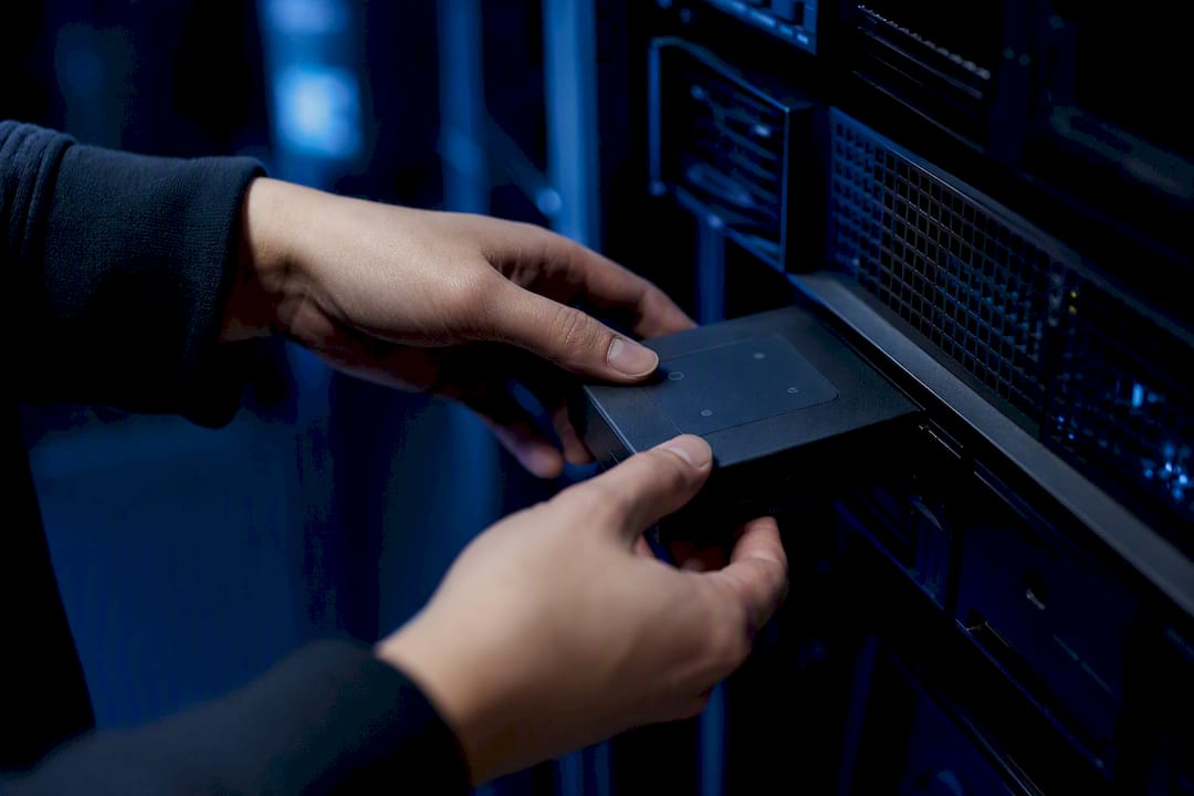 Hands storing an encrypted key device in a server compartment