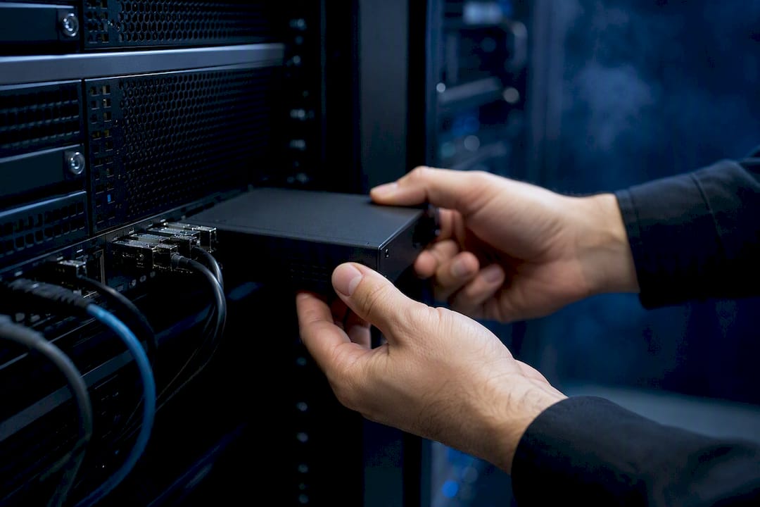 Hands connecting an encryption device in a server rack
