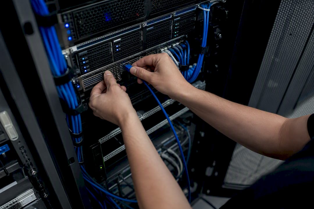 Hand plugging a network cable into a data center rack