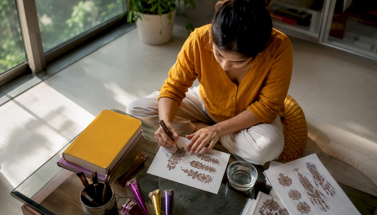 Woman practicing henna application at home