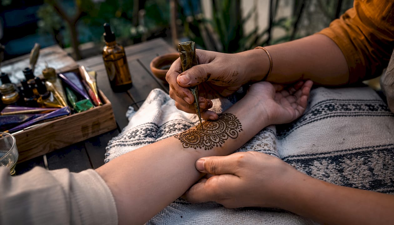 Close-up hands applying henna design