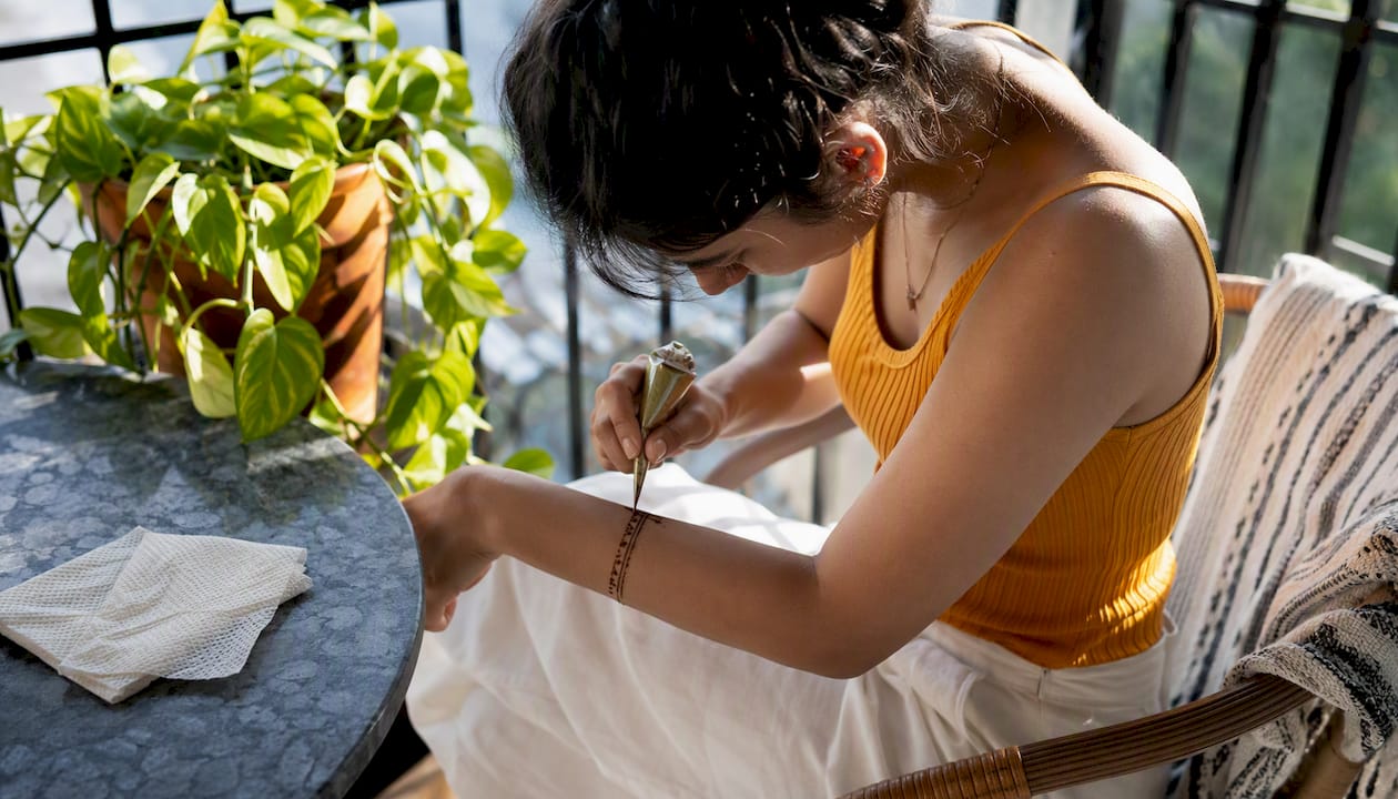 Person applying minimalist henna wrist bracelet