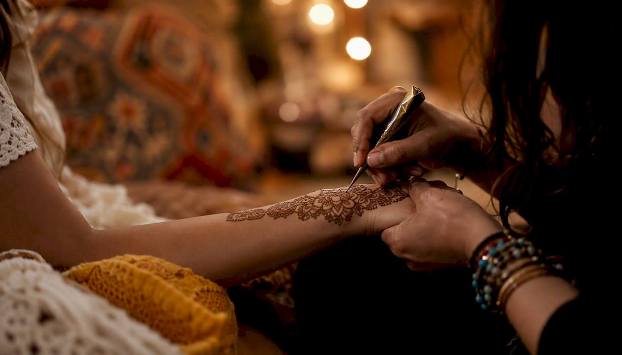 Hands applying henna at bachelorette party