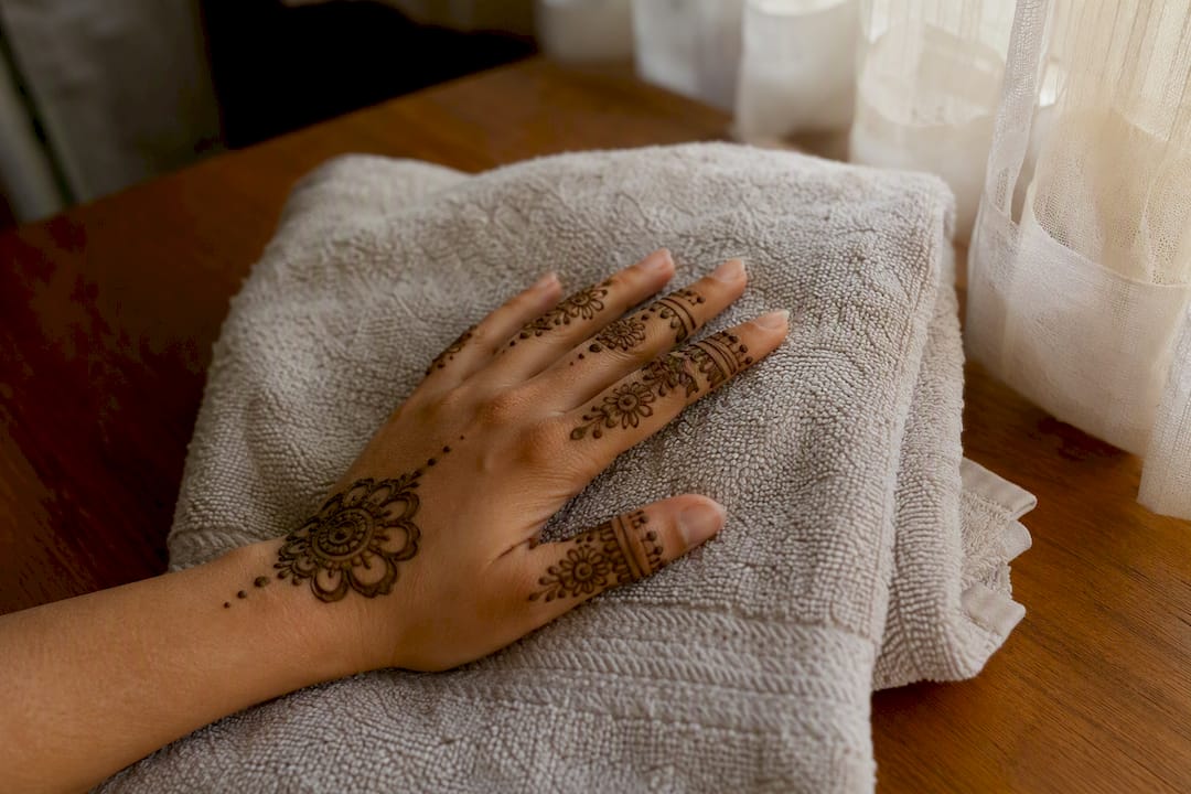 Hand resting on towel while finger henna dries