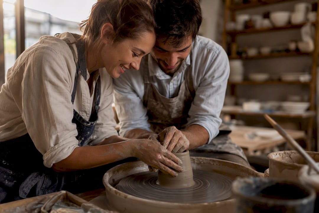 Hands shaping clay on pottery wheel date night