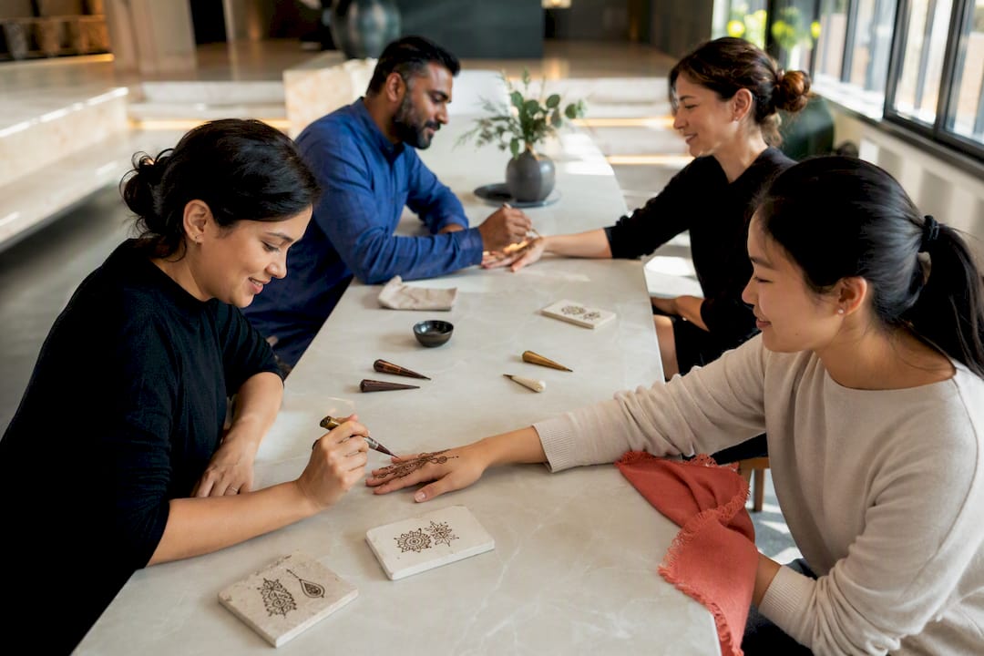 Colleagues practicing henna designs together
