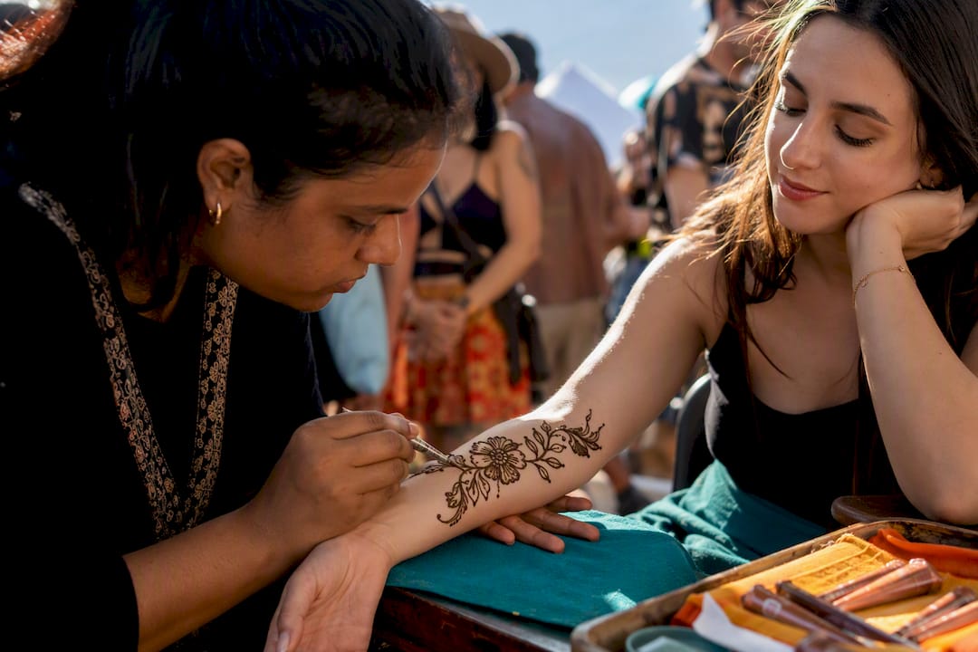 Artist applying fast floral festival henna