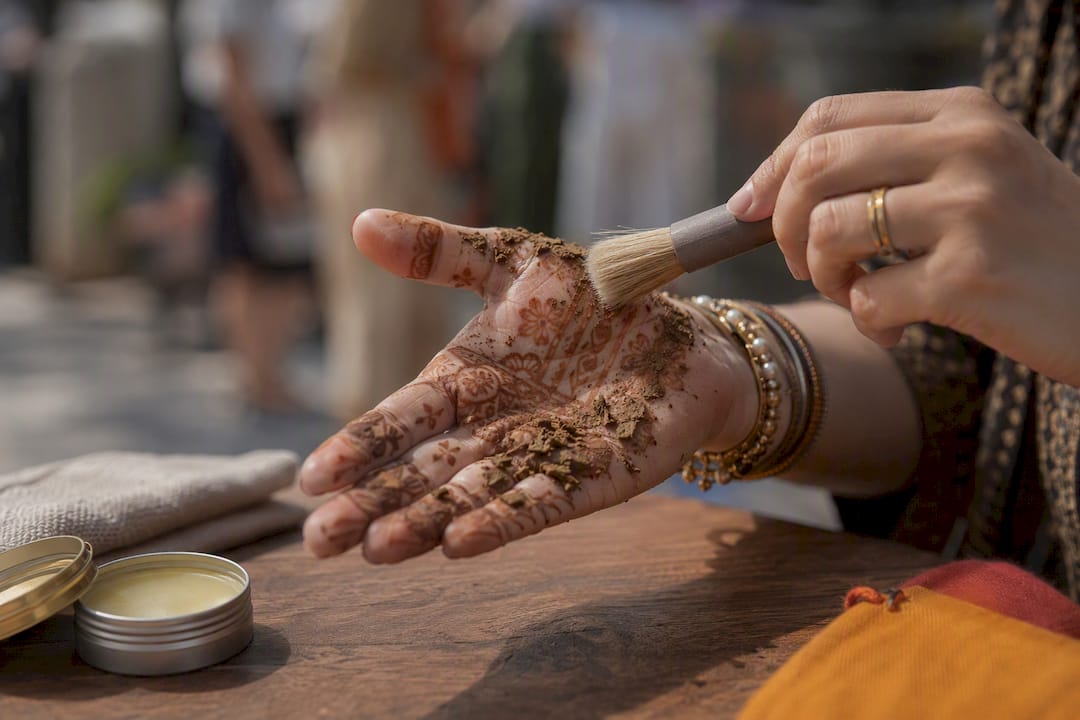Hand brushing dried henna paste flakes