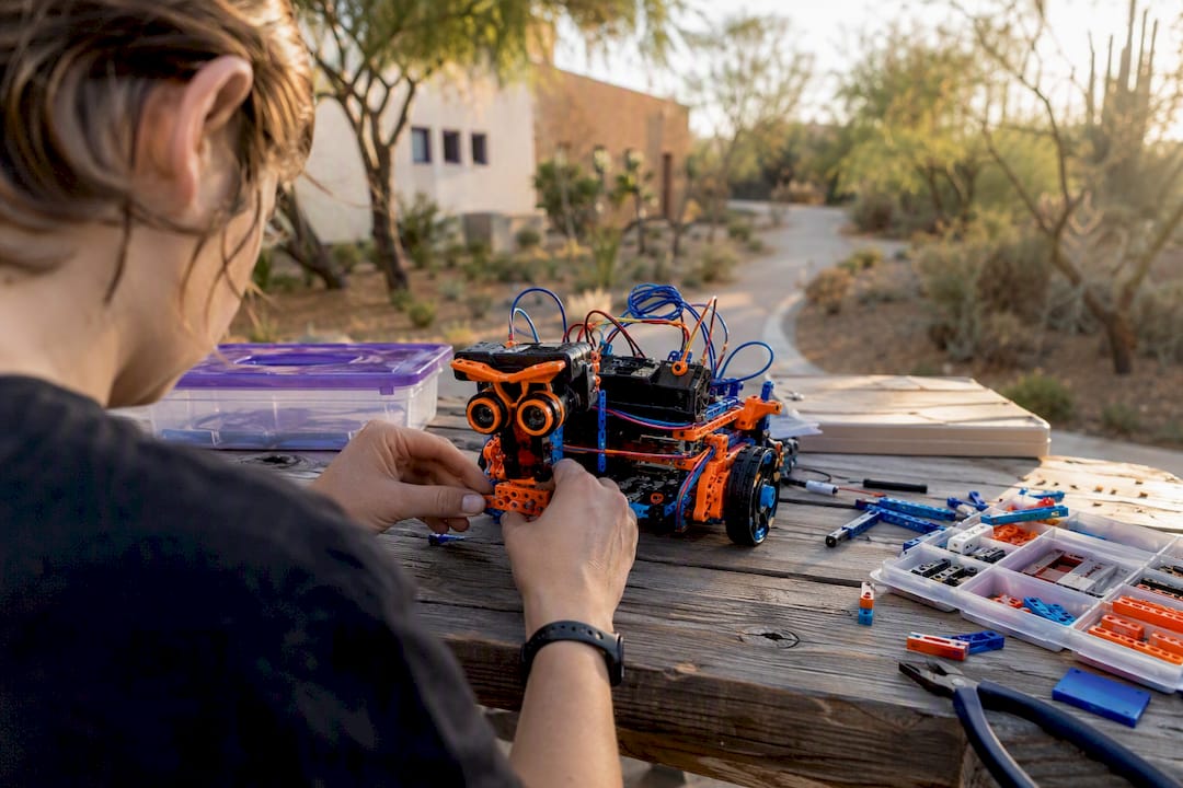 Hands working on robot prototype in science center