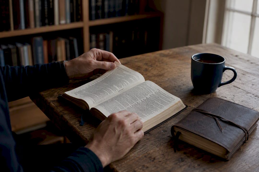 Hands flipping pages of Bible study materials