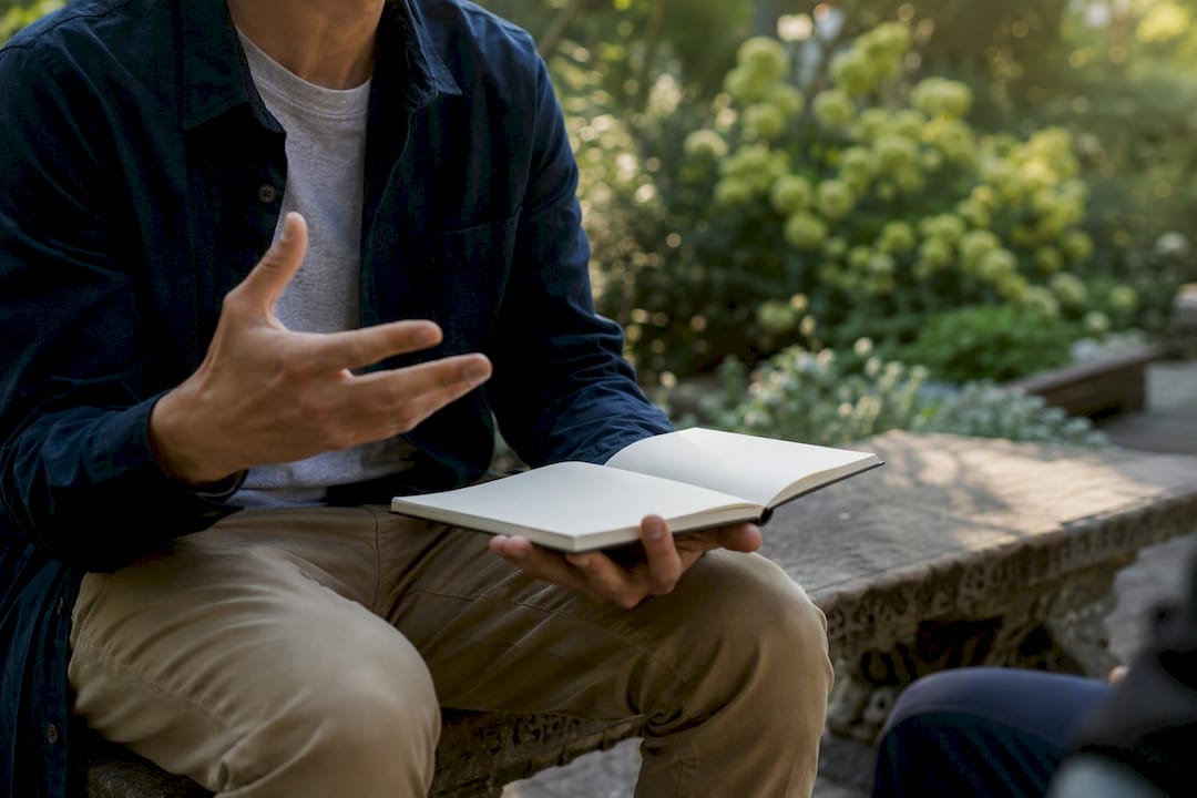 Student discussing theological beliefs outdoors