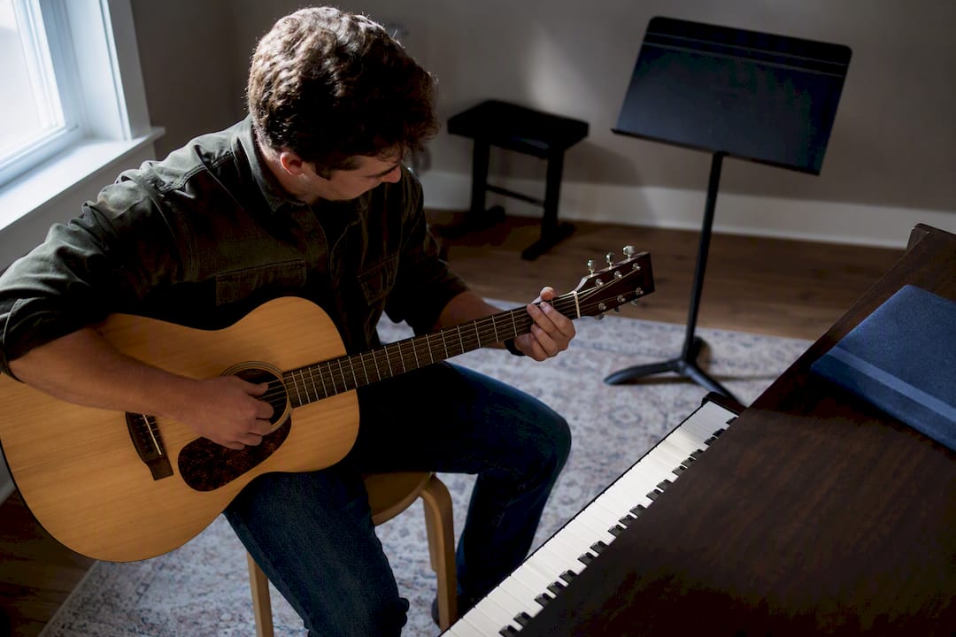 Student practicing guitar and piano skills