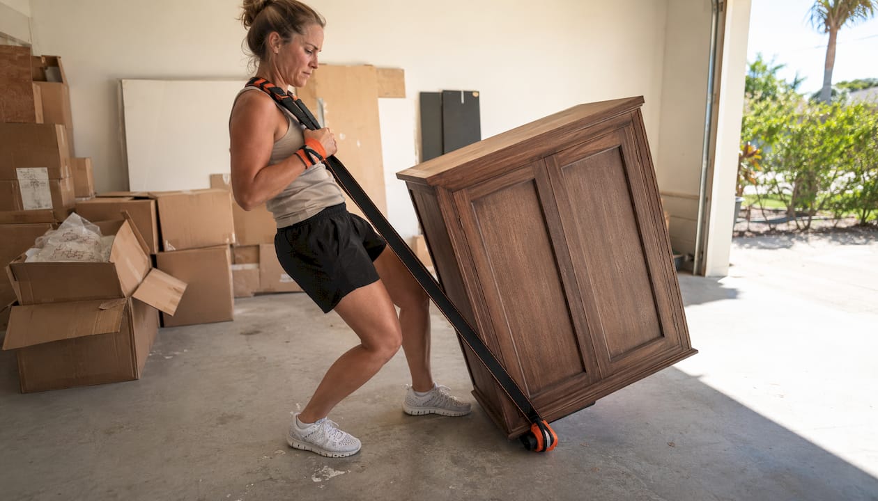 Hands using shoulder dolly and moving blankets
