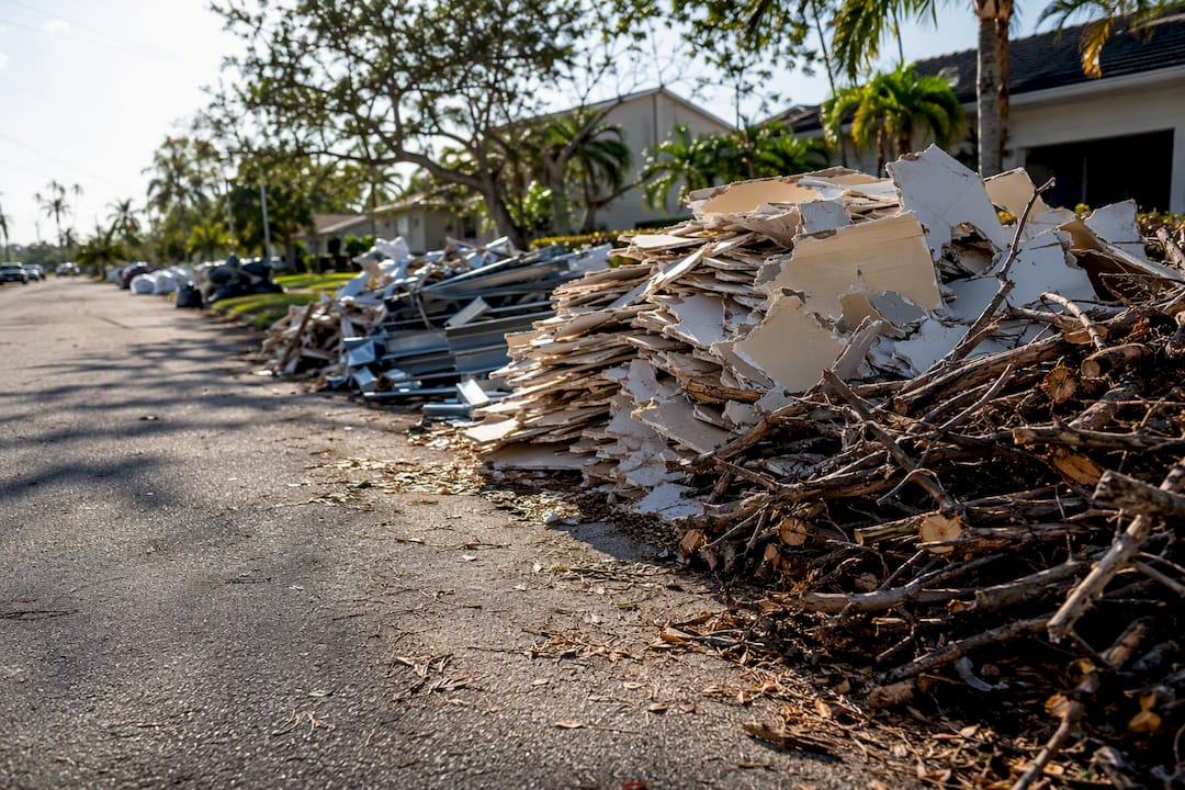Sorted hurricane debris piles by type on street