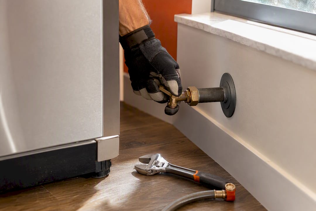Technician turning appliance gas shutoff valve