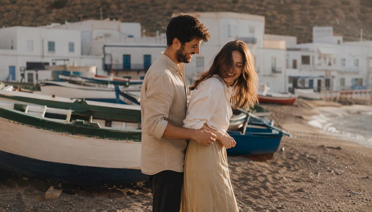 Una pareja pasea junto a las coloridas barcas de pesca en Las Negras.