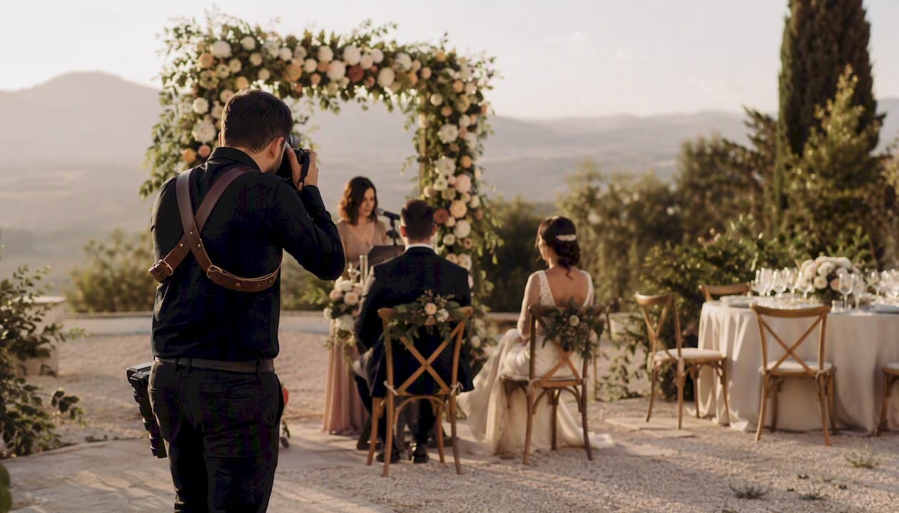 Fotógrafo auxiliar capturando momentos en una boda al aire libre