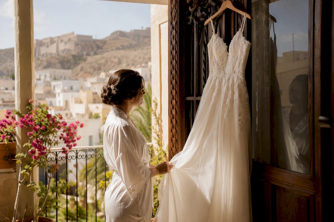 La novia coloca su vestido de boda en el balcón para que luzca perfecto antes de la ceremonia.