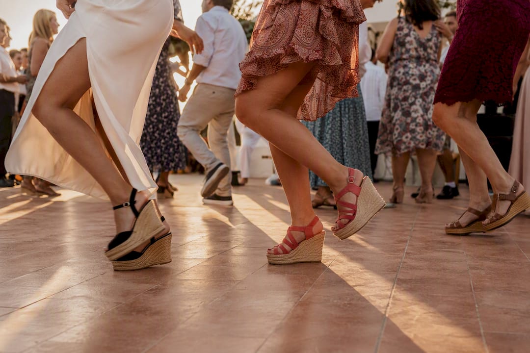 Invitados de boda bailando con energía en una fiesta al aire libre