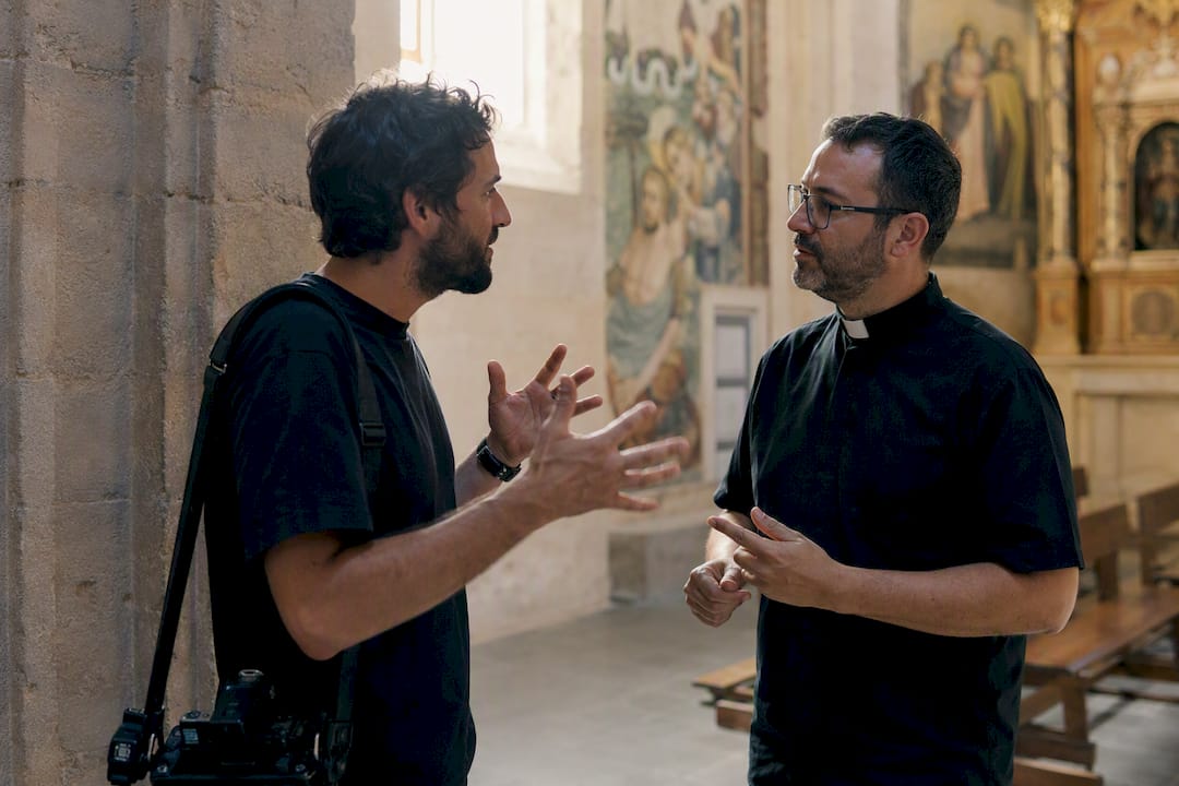 Fotógrafo consultando al sacerdote en la iglesia
