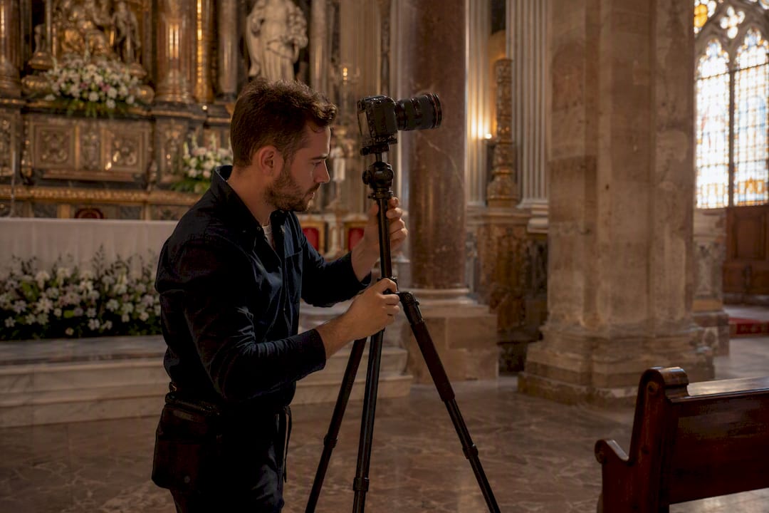 Fotógrafo ajustando el trípode dentro de la iglesia
