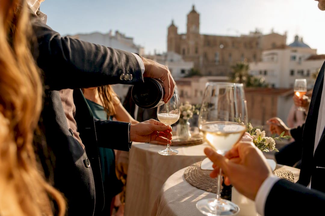 Invitados sirviendo bebidas en el cóctel de boda al aire libre