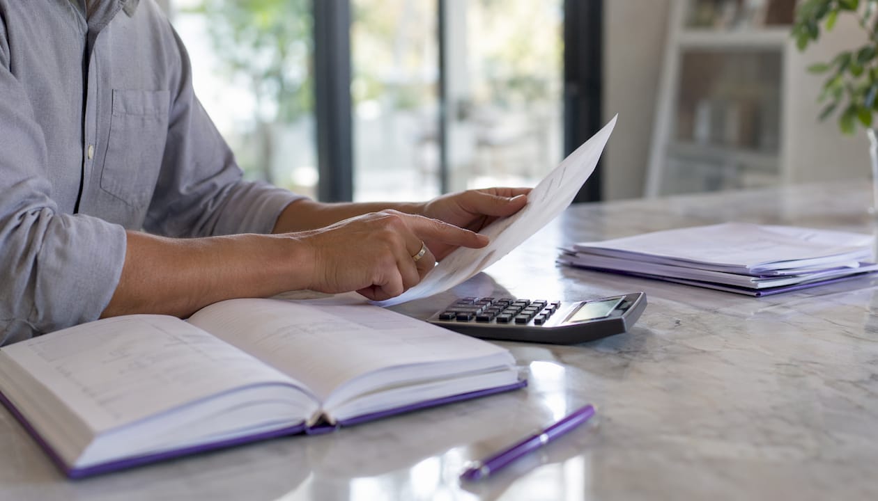 Hands managing accounting documents and calculator