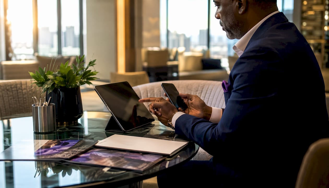 Businessman managing communication on tablet and phone