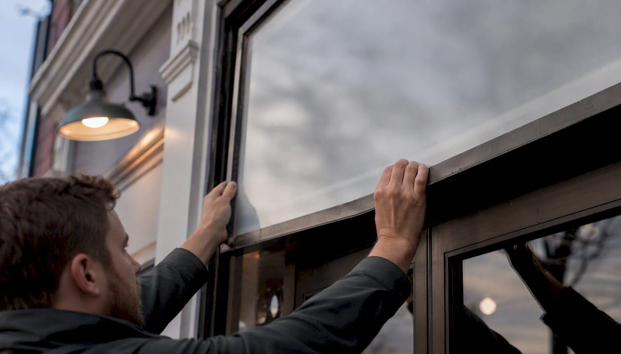 Hands adjusting business signage frame outside