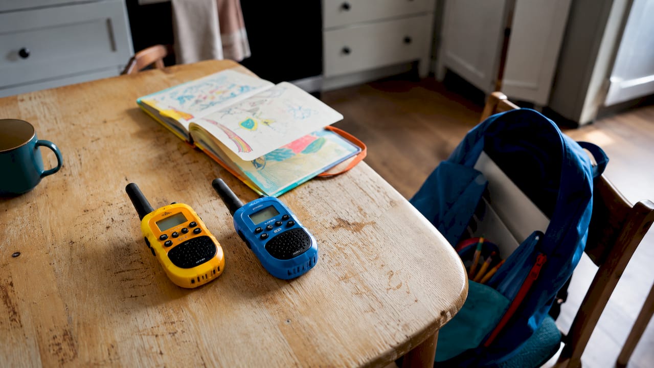 Deux talkies-walkies pour enfants posés sur une table en bois, rappelant les jeux d’antan.