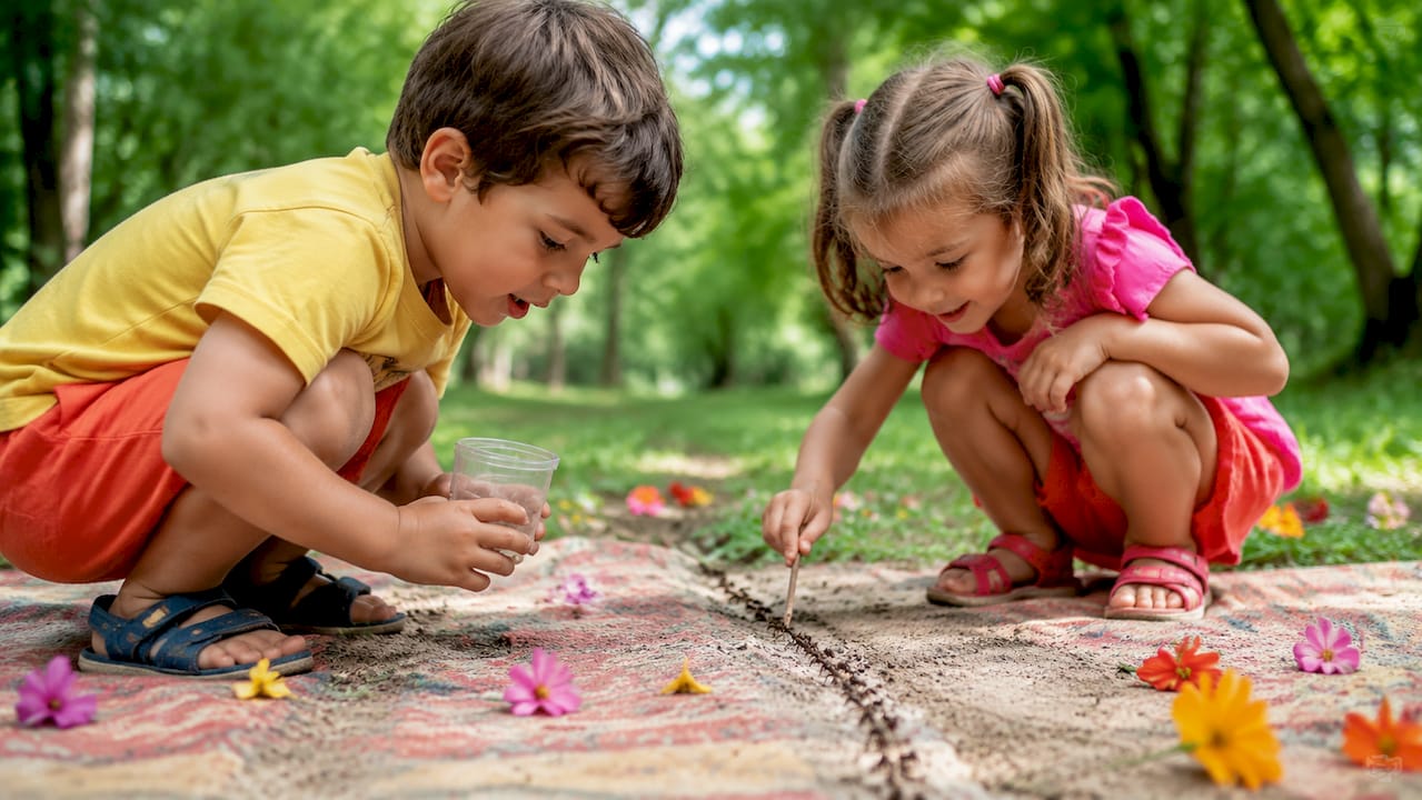 Dans un parc, des enfants intrigués s'accroupissent pour observer de près le va-et-vient des fourmis.