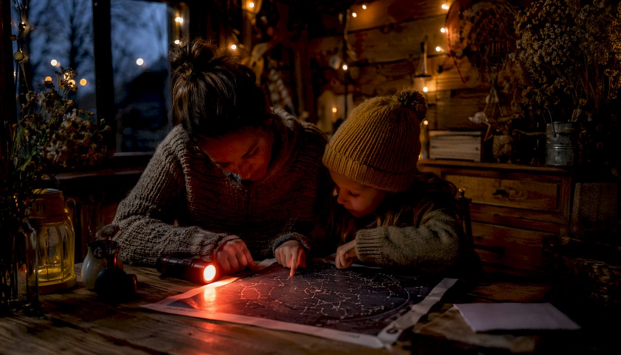 Mother and daughter reading star chart with red light
