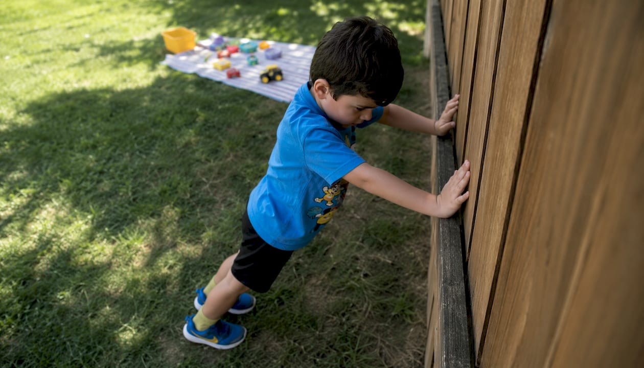 Preschool boy doing wall push-ups for stability