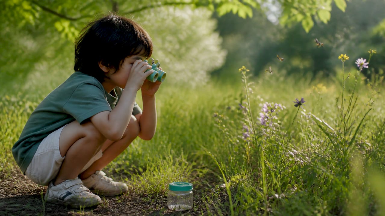 Child outdoors using animal-themed binoculars