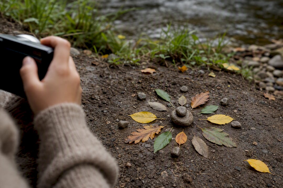 Child photographing an ephemeral leaf mandala