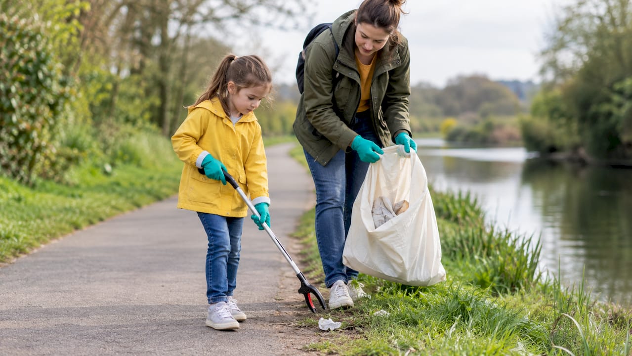 Parent and child collecting litter outdoors