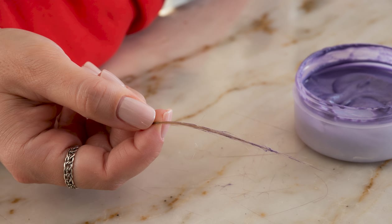 Close-up of hair strand with violet pigment
