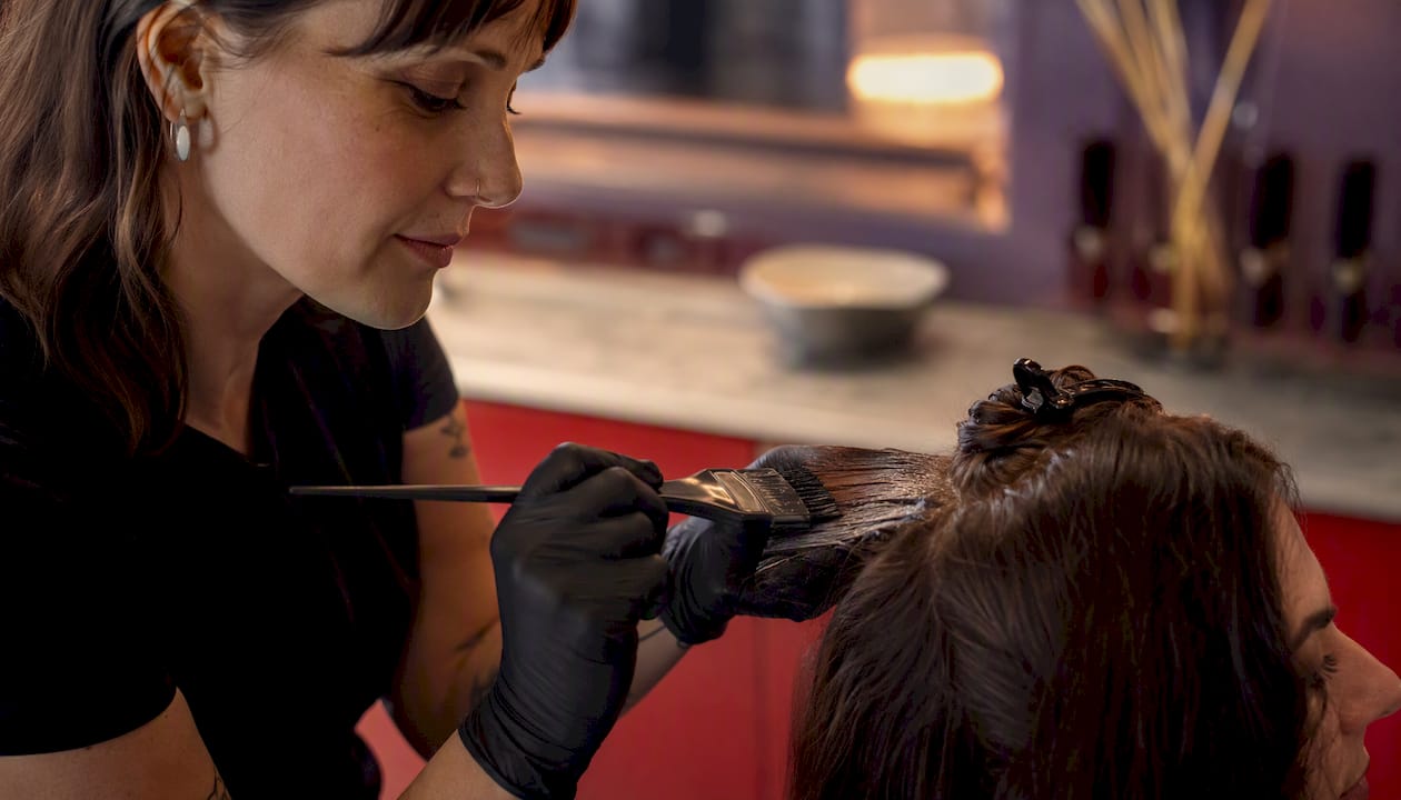 Stylist gently applying demi-permanent hair colour