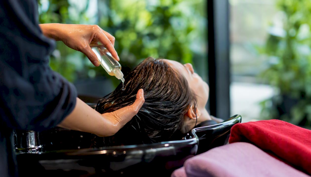 Stylist applying concentrated treatment to hair