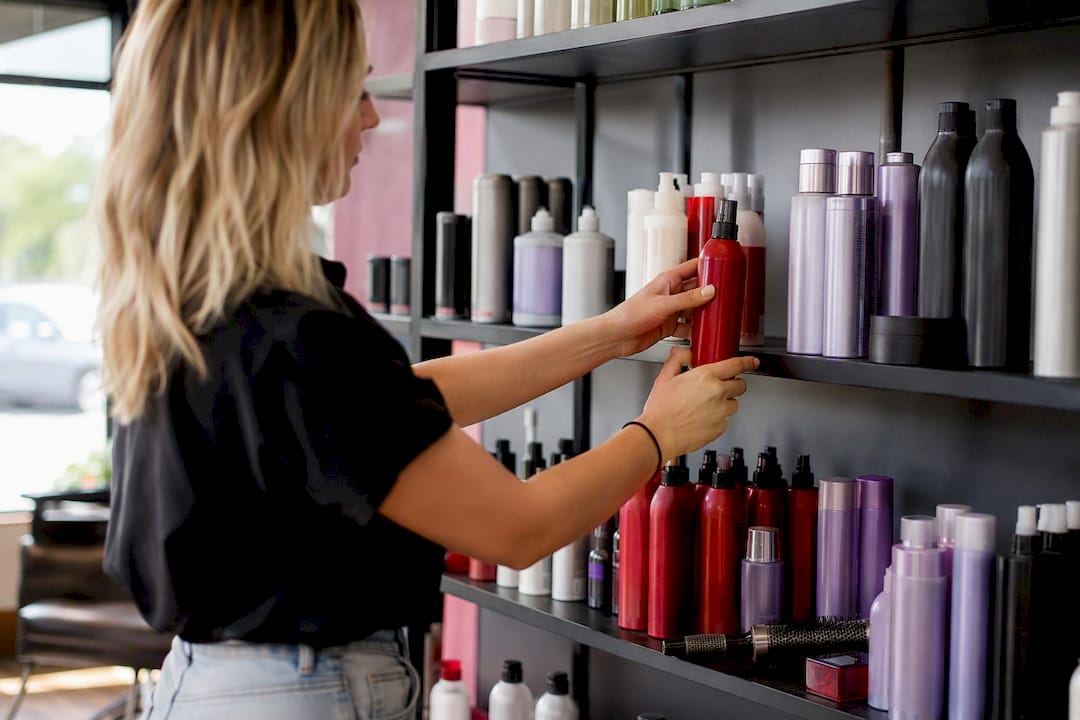 Stylist adjusting haircare display bottles