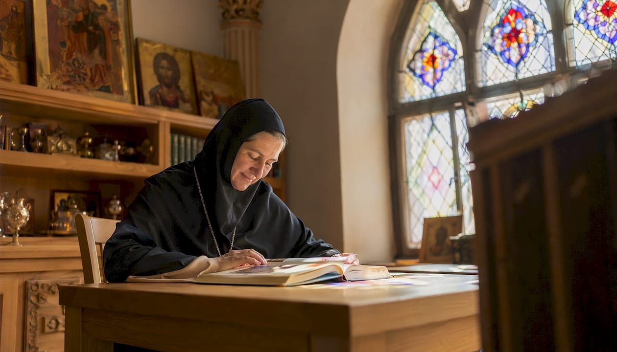 Nun studying historic Byzantine manuscripts in monastery