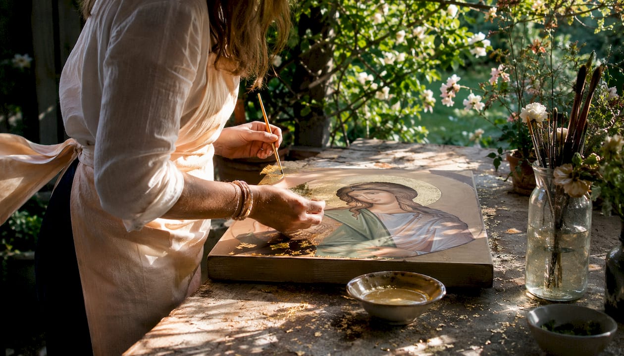 Artisan applying gold leaf to Saint Dymphna icon