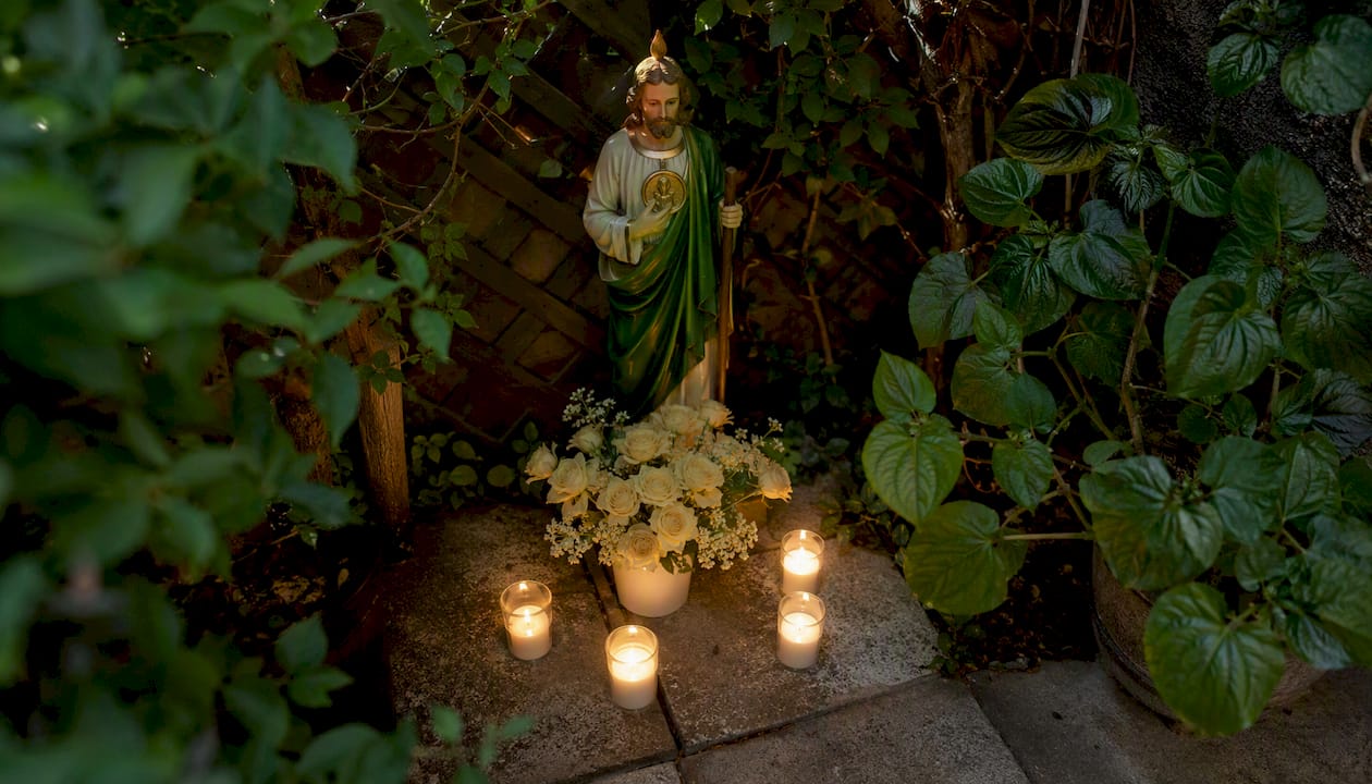 Candles flickering near St. Peregrine statue